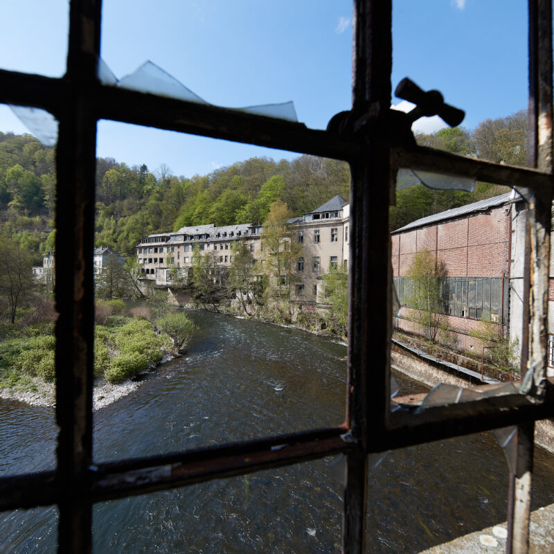 Blick durch ein Gitterfenster der Industrieruine Schwarzenstein in Altena